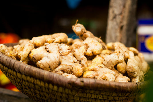 A woven basket of fresh ginger roots at a market.