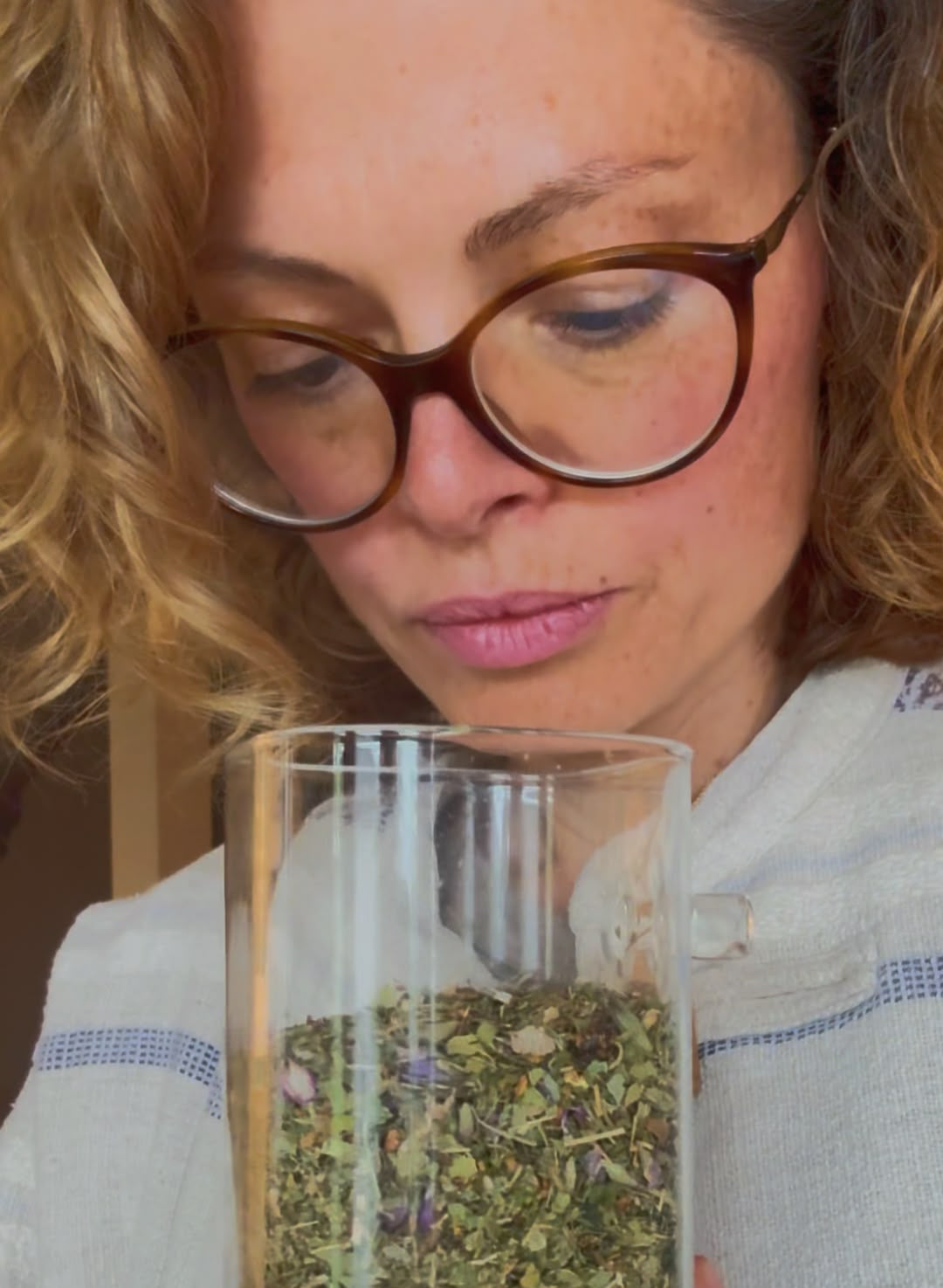 Dominika, TÉHUA's founder, holding a glass of loose-leaf herbal tea blend.